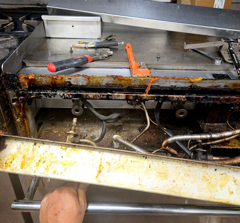 Restaurant-stove-Repair Repairs being done on a stove in a restaurant